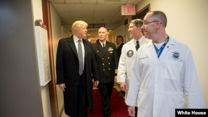 Tổng thống Donald Trump nói chuyện với (từ trái sang phải) Đại tá Mark Kobelja, giám đốc Trung tâm Y tế Quân đội Quốc gia Walter Reed; Bác sĩ Ronny Jackson, bác sĩ của tổng thống; và Bác sĩ James Jones, bác sĩ của tổng thống và giám đốc Đơn vị Thẩm định và Điều trị Y tế, ngày 12 tháng 1, 2018, ở Bethesda, bang Maryland.