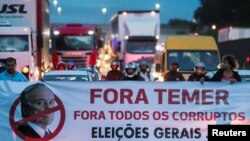 Protestors block the Presidente Dutra highway during a strike against Brazilian Social Welfare reform project from government, in Sao Jose dos Campos, Brazil, March 15, 2017. The banner reads: "Out, Temer. Out, all corrupt. Elections now." 