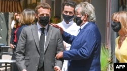 Le président français Emmanuel Macron (à gauche) s'entretient avec le restaurateur Michel Chabran alors qu'il arrive pour un déjeuner à Valence, le 8 juin 2021.