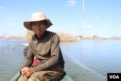 Fut Kheun, 39, a victim of Chinese-built 400-megawatt Lower Sesan 2 Dam, drives a motorized boat to see the submerged villages, Stung Treng province, Nov 28, 2018. (Sun Narin/VOA Khmer)