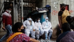 Health workers in personal protective equipment rest during a check up campaign for the coronavirus disease (COVID-19) at a slum area in Mumbai, India, August 3, 2020. REUTERS/Francis Mascarenhas