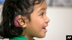 FILE - Angelica Lopez, 3, smiles during deafness therapy session at the University of Southern California, Los Angeles, Feb. 11, 2015.