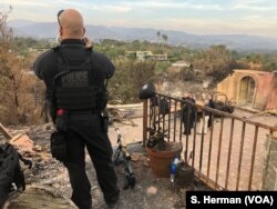 While a Secret Service member stands watch, President Donald Trump, along with California officials including, Gov. Jerry Brown and Gov.-elect Gavin Newsom, survey the damage done by the Woolsey Fire in Malibu, Calif., Nov. 17, 2018.