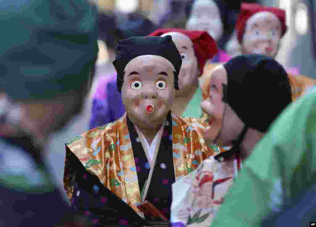 Artists wearing traditional Japanese clown masks march during the First Konpira Festival, at Kotohiragu shrine in Tokyo.