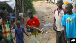 Un groupe d'enfants jouent avec une arme-jouet dans l'enceinte du site pour les civils sous la protection des Nations Unies, à Juba, Soudan du Sud, 25 juillet 2016.
