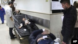 In this photo released by the Syrian official news agency SANA, Syrian injured men wait to receive medical treatments after they wounded in the main judicial building, which was attacked by a suicide bomber, in Damascus, Syria, March 15, 2017.