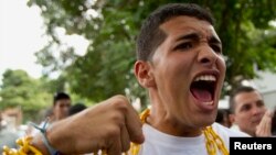 Estudiantes venezolanos rezan mientras se encadenas durante una protesta frente a la embajada de Cuba.