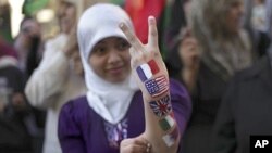 A Libyan girl shows a victory gesture with her arm painted with French, U.S., Great Britain, Italian and Qatari flags during a demonstration in Benghazi, Libya, Thursday, March 31, 2011 (AP Photo/Altaf Qadri)