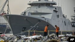 Miembros de la Agencia Nacional de Búsqueda y Rescate inspeccionan los residuos recuperados de las aguas donde se cree que se estrelló el vuelo JT 610 de Lion Air, en el puerto de Tanjung Priok en Yakarta, Indonesia, el miércoles 31 de octubre de 2018.