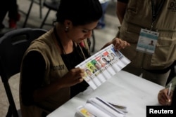 A woman takes part in a hand count of some of the votes cast in Honduras' recent presidential election in Tegucigalpa, Dec. 7, 2017.