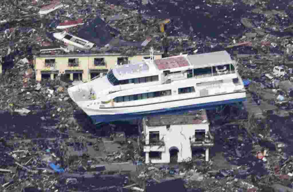 Un ferry ha sido desplazado por las gigantescas olas hasta quedar colgado sobre el tejado de una casa.