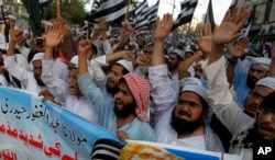 FILE - Supporters of a Pakistani religious group Jamiat-e-Ulema Islam, chant slogans during a demonstration to condemn a suicide bombing the day before, in Karachi, Pakistan, May 13, 2017. The Islamic State group said it carried out the attack on a Pakistani lawmaker in Baluchistan province that killed 25 people despite a protracted crackdown on the assortment of militant groups operating in Pakistan.