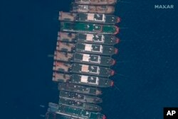 太空技术公司Maxar Technologies提供的这张卫星图像显示，众多中国船只3月23日停泊在南中国海有争议的牛轭礁附近。