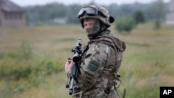 FILE - A Ukrainian soldier stands during training in a landfill at Chuguev, Ukraine, June 4, 2014.