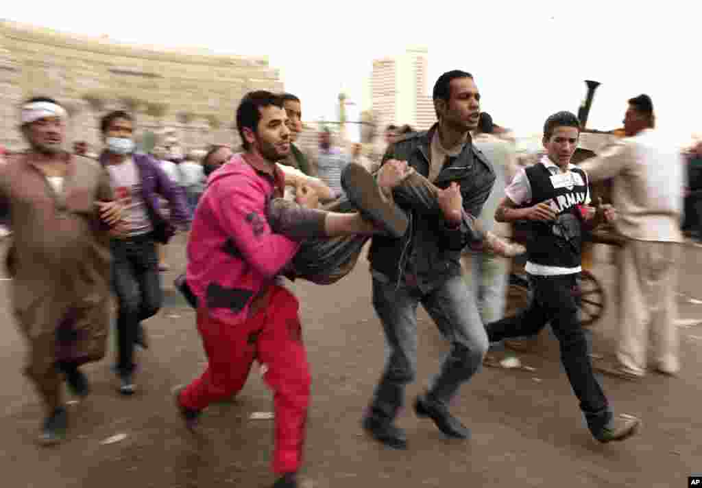 Protesters rush a wounded comrade to a field hospital in Tahrir Square, Cairo, Egypt, November 23, 2012. 