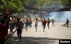 Protesters run from tear gas being fired by police during Irreecha, the thanks giving festival of the Oromo people in Bishoftu town of Oromia region, Ethiopia, Oct. 2, 2016.