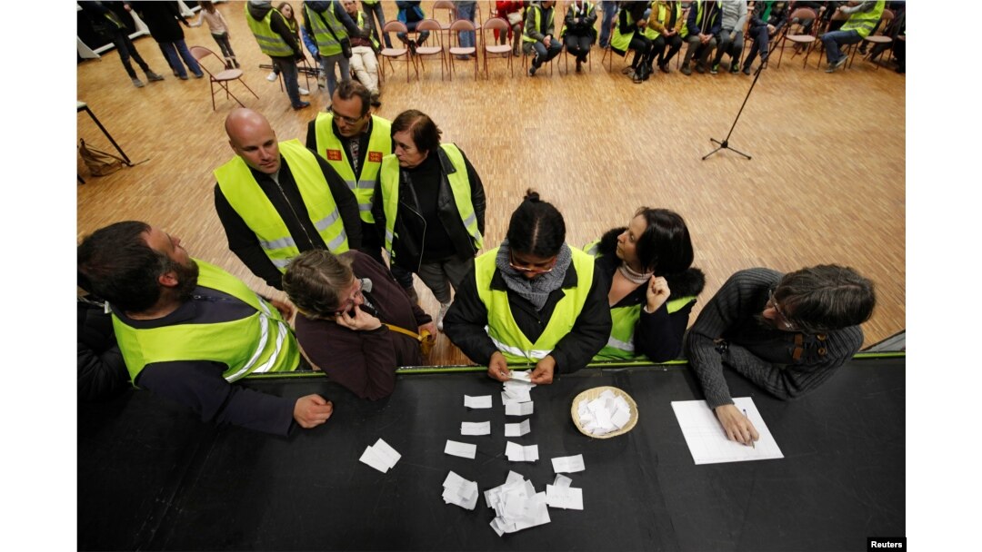 Protesters wearing yellow vests, the symbol of a French protest against higher diesel fuel prices, count ballots as they elect a representative to liaise with other blockade points, in Aubevoye, France, Dec. 6, 2018.