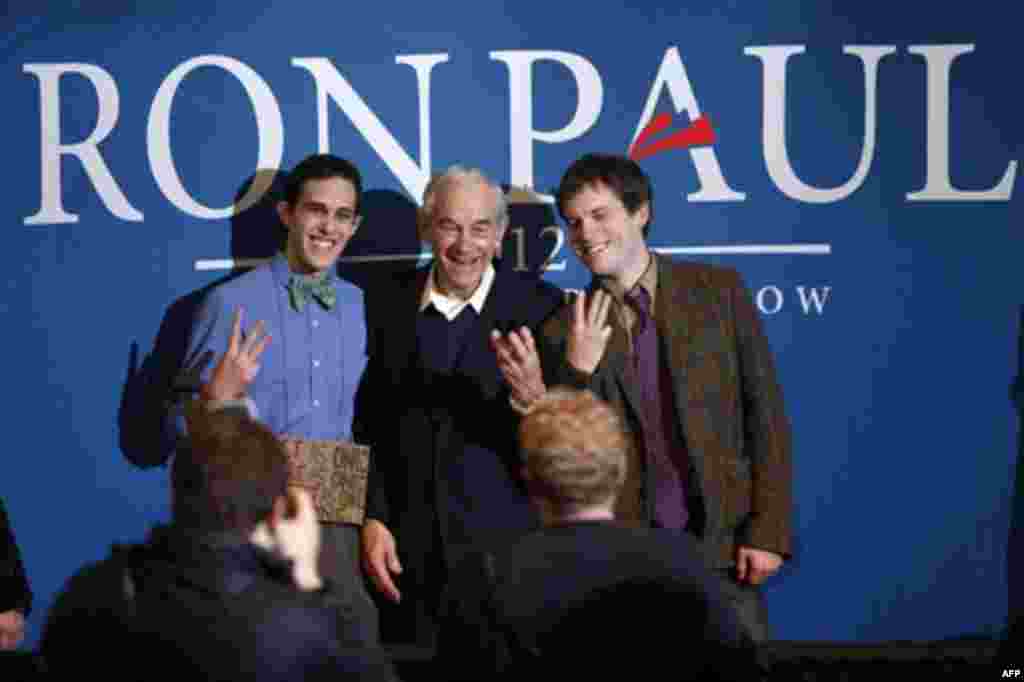 Republican presidential candidate, Rep. Ron Paul, R-Texas, joins Colby College students Brian Russo, of Wakefield, Mass., left, and Jack Harris of Greenwich, Conn., in a sustainability salute, at campaign stop, Friday, Jan. 27, 2012, in Waterville, Maine.