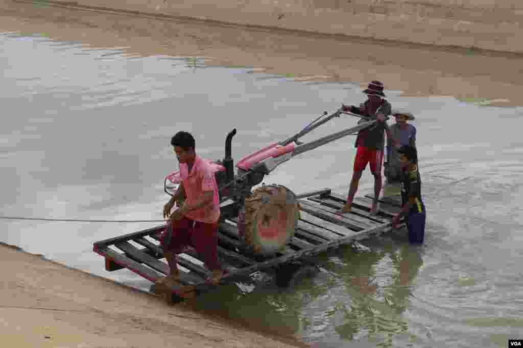 កសិករដាក់គោយន្តក្នុងប្រឡាយទឹក ជាម៉ាស៊ីន ដើម្បីបូមទឹក ដាក់ស្រែរបស់ពួកគេក្នុងឃុំត្រពាំងជង ស្រុកបាកាន ខេត្តពោធិ៍សាត់។ (ស៊ុន ណារិន/VOA Khmer)