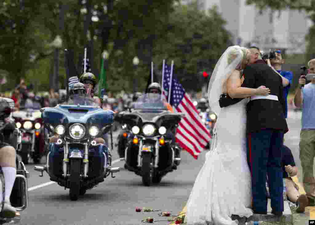 Pasangan pengantin baru Tim Chambers, seorang Marinir AS, dan Lorraine Heist berciuman saat iring-iringan motor besar &#39;Rolling Thunder&#39; melakukan parade Hari Pahlawan di Washington DC.