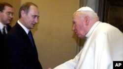 Pope John Paul II and Russian President Vladimir Putin shake hands at the Vatican, June 5, 2000.