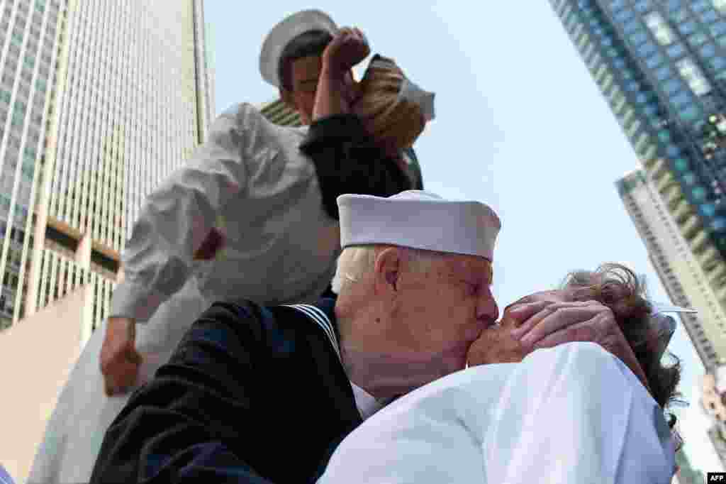 Veteran Perang Dunia II Ray dan&nbsp;​Ellie Williams melakukan reka ulang &quot;ciuman&quot; yang ikonik seperti tertangkap dalam foto jepretan&nbsp;​Alfred Eisenstaedt di Times Square di New York City. Pasangan Williams yang keduanya veteran Angkatan Laut Amerika juga merayakan ulang tahun pernikahan mereka yang ke-70.