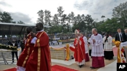 Paus Fransiskus (tengah) didampingi para pastur berjalan menuju member untuk menggelar misa di dekat mama para martir Katolik di Namugongo, Kampala, Uganda (28/11).