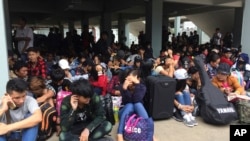 ထိုင်းနိုင်ငံ၊ တာ့ခ်ခရိုင် မဲဆောက်မြို့ လဝကရုံးရှေ့မှာ လိုရာခရီးမထွက်ခင် စောင့်ဆိုင်းနေကြတဲ့ မြန်မာရွှေ့ပြောင်းအလုပ်သမားများ။ (ဇူလိုင် ၃၊ ၂၀၁၇)