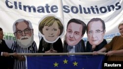 FILE: Environmental protesters wear masks depicting European officials during a demonstration in Brussels. Taken Sept. 18, 2015