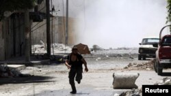A man runs for cover during clashes between Free Syrian Army fighters and Syrian Army soldiers in the Salah al-Din neighborhood of central Aleppo August 4, 2012.