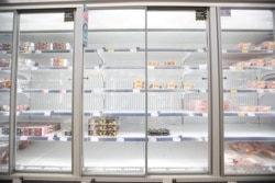 FILE - Empty shelves are seen in the meat aisle of Co-Op supermarket, Harpenden, Britain, Sept. 22, 2021.