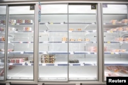 FILE - Empty shelves are seen in the meat aisle of Co-Op supermarket, Harpenden, Britain, Sept. 22, 2021.