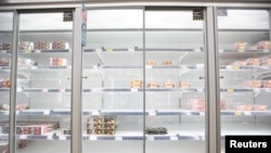 FILE - Empty shelves are seen in the meat aisle of Co-Op supermarket, Harpenden, Britain, Sept. 22, 2021.