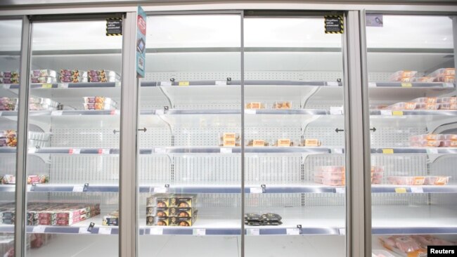 FILE - Empty shelves are seen in the meat aisle of Co-Op supermarket, Harpenden, Britain, Sept. 22, 2021.