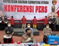 Kapolda Sumut, Irjen Pol RZ Panca Putra saat memberikan konferensi pers di Medan hari Jumat (21/5) sore. Ke-4 tersangka jual-beli vaksin tampak berada di belakang (Foto: VOA/Anugrah Andriansyah)