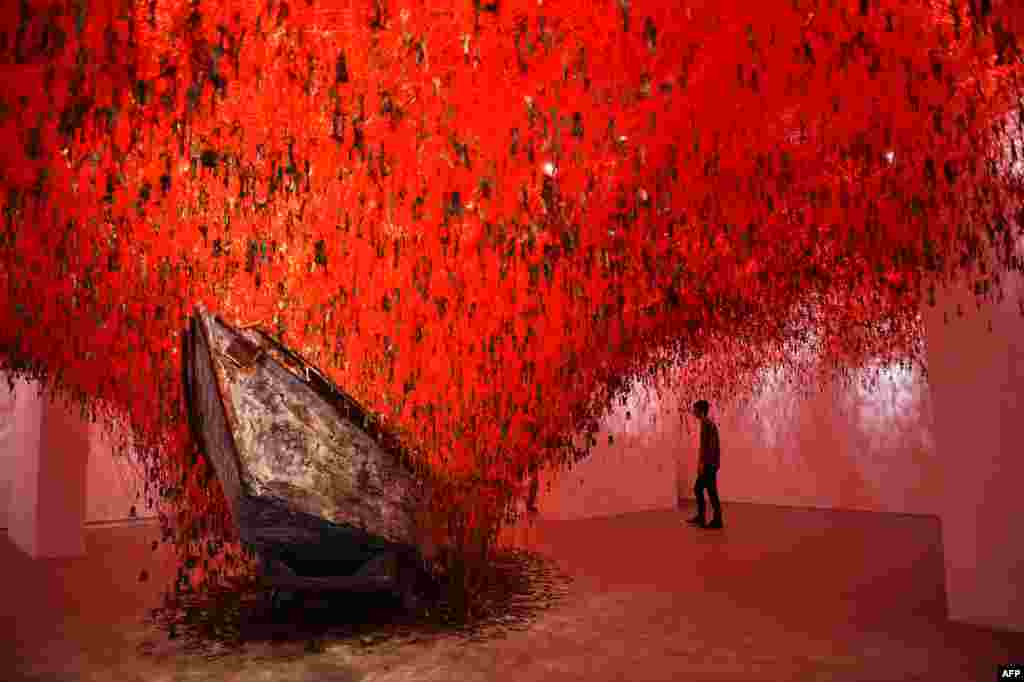 Seorang pengunjung memperhatikan &quot;The Key in the Hand&quot; karya seni oleh artis Jepang Chiharu Shiota yang ditampilkan di paviliun Jepang di Pameran Seni Internasional ke-56 (Biennale d&#39;Arte) berjudul &quot;All the World&rsquo;s Futures,&quot; di Venesia, Italia.