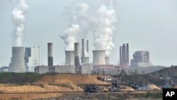 Machines dig for brown coal in front of a smoking power plant near the city of Grevenbroich in Germany. The Paris Agreement, which formally starts November 4, 2016, seeks to wean the world economy off fossil fuels.
