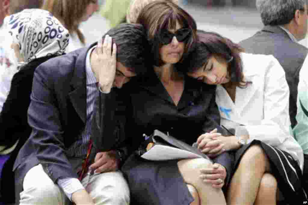 Alicia Bergstein, center, comforts her children Devin Bergstein, left, and Adrianna Bergstein while visiting the National September 11 Memorial at the World Trade Center site in New York, Sunday, Sept. 11, 2011. Daniel Bergstein, Alicia husband and the ch