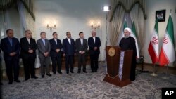 In this photo released by official website of the office of the Iranian presidency, President Hassan Rouhani addresses the nation in a televised speech in Tehran, May 8, 2018. Rouhani said he'd send his foreign minister to negotiate with countries remaining in the nuclear deal after President Donald Trump's decision to pull America from the deal, warning he otherwise would restart enriching uranium "in the next weeks."