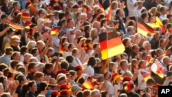 FILE - The June 26, 2011 file photo shows soccer fans waving German flags during the group A match between Germany and Canada at the Women’s Soccer World Cup in Berlin, Germany. 