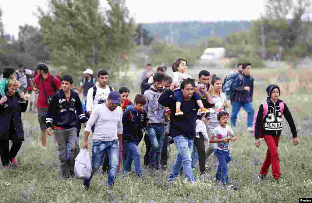 Migrants walk away from the border crossing from Hungary in Nickelsdorf, Austria. Austria announced it would dispatch the armed forces to guard its eastern frontier, following Germany&#39;s lead in reimposing Europe&#39;s internal border controls after thousands of migrants streamed across its frontier from Hungary on foot.