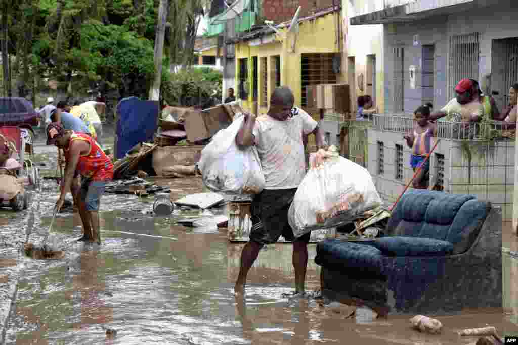 Warga kota Barreiros, Brazil, berusaha menyelamatkan barang-barang mereka dari banjir akibat hujan lebat melanda negara bagian Pernambuco, Brazil timur laut.