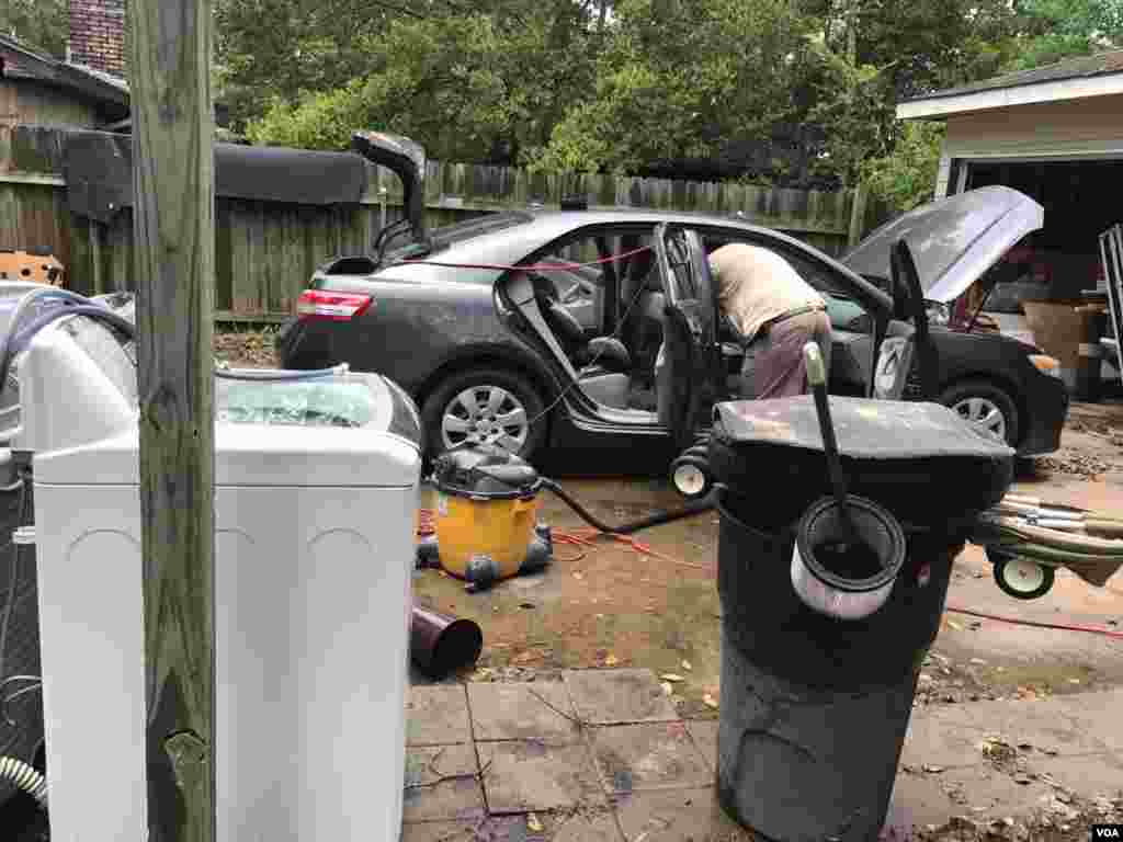 Residente en Houston limpia su auto una vez que las aguas de la inundación causada por la tormenta tropical Harvey comenzaron a bajar.