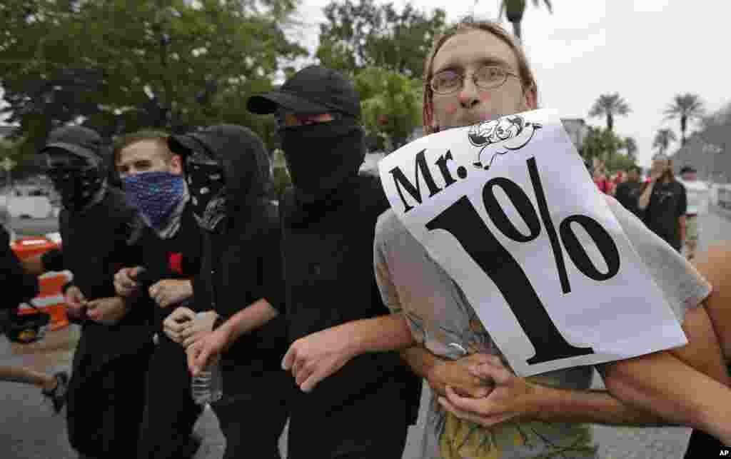 Manifestantes que protestan contra la convención republicana de Tampa, se refieren a los delegados como “señor 1%”.