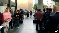 FILE - Immigrants awaiting deportation hearings line up outside the building that houses the immigration courts in Los Angeles, June 19, 2018. 
