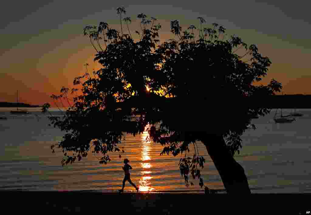 A runner gets in her exercise at dawn on Willard Beach in South Portland, Maine.