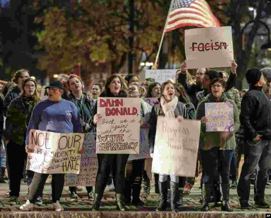 Demonstrators wave signs against the election of Donald Trump as president during a protest in downtown Omaha, Nebraska, Nov. 11, 2016.