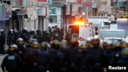 French special police forces secure the area as shots are exchanged in Saint-Denis, France, near Paris, during an operation to catch fugitives from Friday night's deadly attacks in the capital, Nov. 18, 2015.