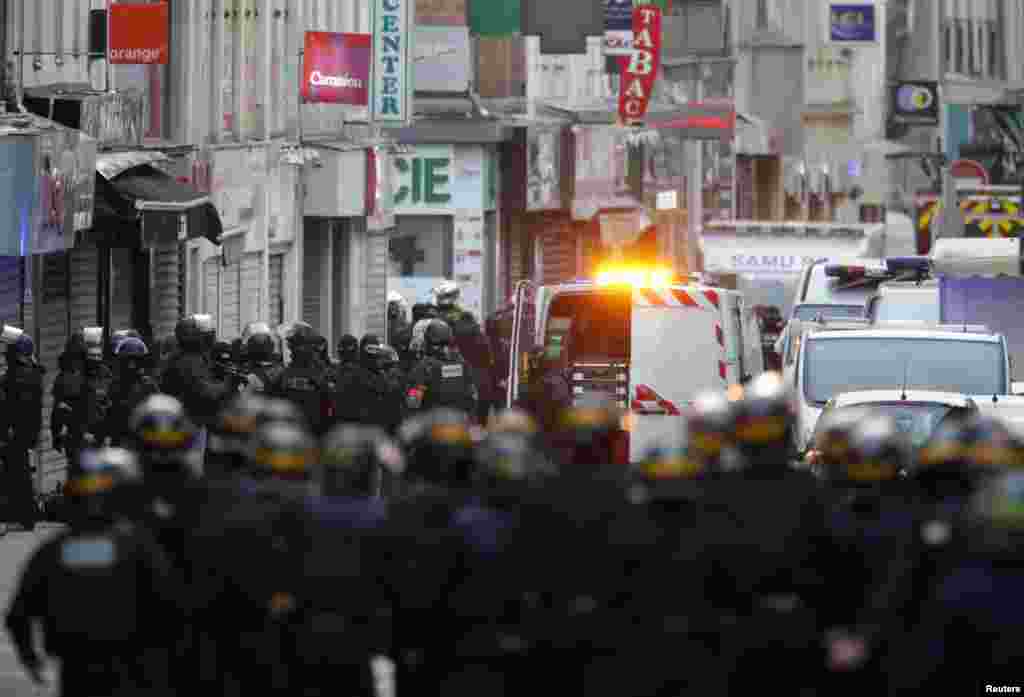 French special police forces secure the area as shots are exchanged in Saint-Denis, France, near Paris, during an operation to catch fugitives from Friday night's deadly attacks in the capital, Nov. 18, 2015.