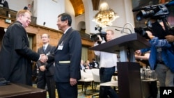 Attorney General of Australia Mark Dreyfus (far left) shakes hands with Japanese Deputy Minister of Foreign Affairs Koji Tsuruoka (second left) at the International Court of Justice in The Hague, Netherlands, June 26, 2013. 